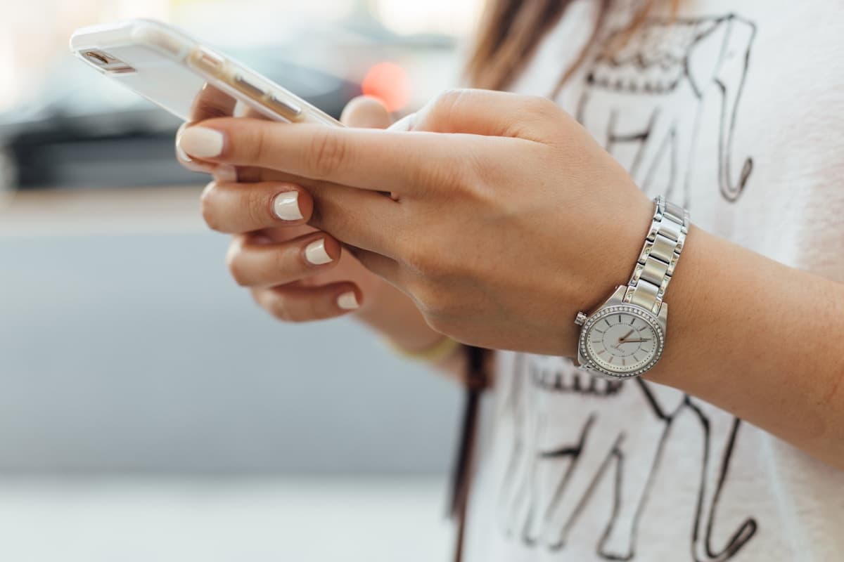 Dłoń trzymająca telefon z wiadomościami